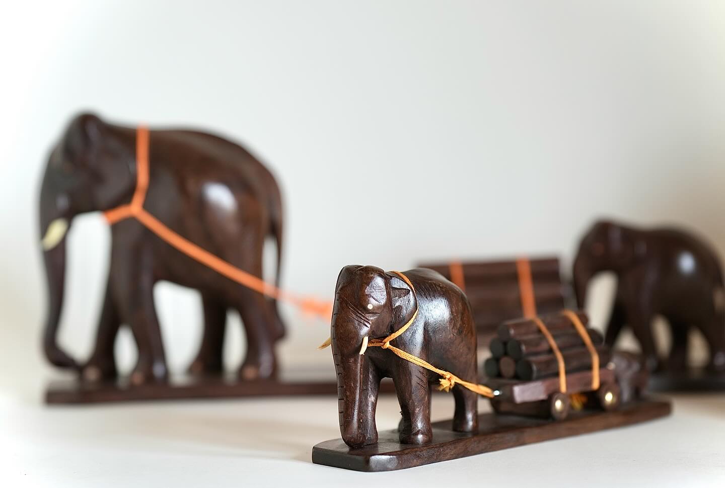 Elephant pulling a loaded wooden cart with a calf assisting from behind. Size: 12 inches.