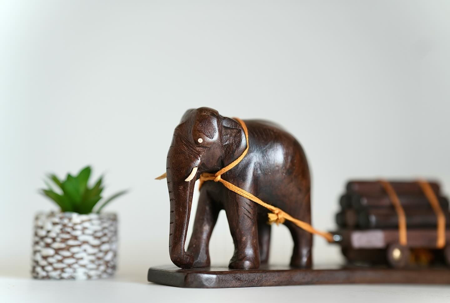 Elephant pulling a loaded wooden cart with a calf assisting from behind. Size: 12 inches.